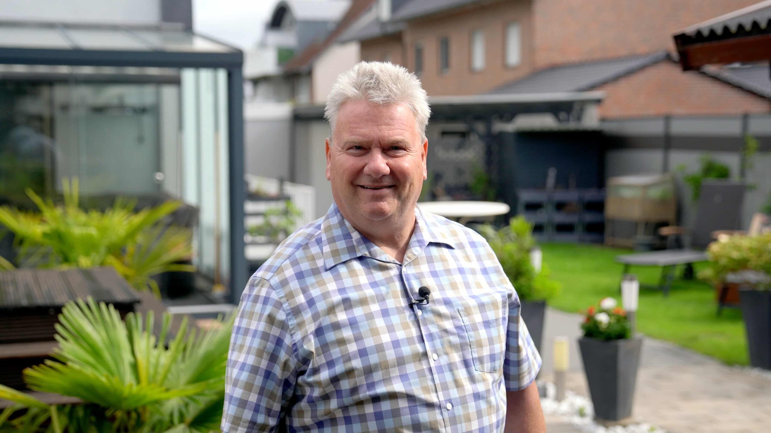 Holger Kunde von Homenergy mit PV Komplettanlage mit Wärmepumpe guckt lachend in die Kamera.